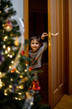 A little boy enters the room on New Year's Eve and looks at the Christmas tree with surprise - PhotoDune Item for Sale