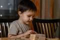 A little boy builds a tower of wooden sticks - PhotoDune Item for Sale