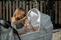 The older sister is playing with the baby. Baby in a stroller - PhotoDune Item for Sale