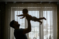 Silhouettes. Dad throws up a happy baby - PhotoDune Item for Sale