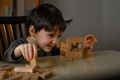 A little boy builds a tower of wooden sticks - PhotoDune Item for Sale