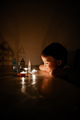The boy in the dark room is looking at the burning candles. Dark Keys - PhotoDune Item for Sale