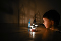 The boy in the dark room is looking at the burning candles. Dark Keys - PhotoDune Item for Sale