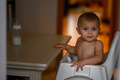 The baby is sitting in a high chair at home in the kitchen - PhotoDune Item for Sale