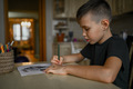A 10-year-old boy draws a drawing with colored pencils - PhotoDune Item for Sale