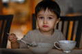 A little boy eats porridge for breakfast - PhotoDune Item for Sale