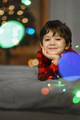 Portrait of a five-year-old boy. A boy in red pajamas and a glowing garland - PhotoDune Item for Sale