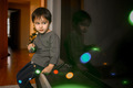 A three-year-old boy plays with a glowing garland - PhotoDune Item for Sale