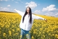 Portrait of young woman enjoying spring in a mustard field on sunny day - PhotoDune Item for Sale