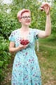 woman in blue dress holding handful of sweet cherries in garden farm orchard on summer day. - PhotoDune Item for Sale