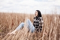Young woman with long hair, sitting on grass, outdoors. - PhotoDune Item for Sale