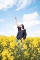 Happy smiling woman in the field of yellow blooming flowers - PhotoDune Item for Sale