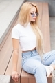 Stylish girl in blue denim pants posing on the city street.  - PhotoDune Item for Sale