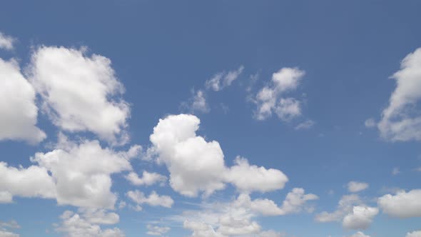 Time lapse of clear blue sky with white fluffy clouds at noon. Day time