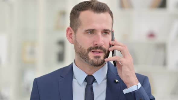 Portrait of Cheerful Businessman Talking on Smartphone