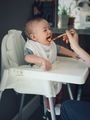 Happy baby taking a big bite of food - PhotoDune Item for Sale