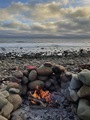 Wood burning fire pit on a rocky beach at golden hour - PhotoDune Item for Sale