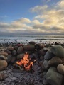 Wood burning fire pit on a rocky beach at golden hour - PhotoDune Item for Sale