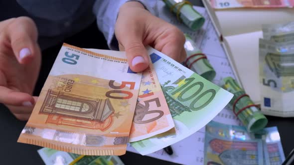 Slow Motion Business Woman Displaying a Spread of Cash Euros