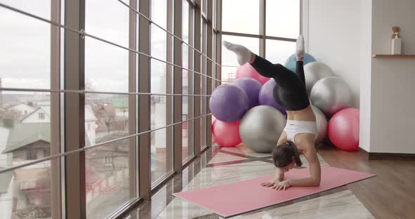 Athletic Woman Stretching on a Mat in a Fitness Studio