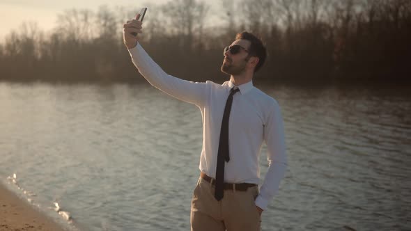 Man Taking Selfie Portrait On Smartphone. Selfie On Mobile Phone In Beautiful Place.