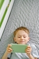 Close up of a smiling preschool boy using cellphone for playing, watching video, video chatting.  - PhotoDune Item for Sale