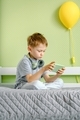 A kid using cellphone. A cute preschool boy playing a game on mobile phone. - PhotoDune Item for Sale
