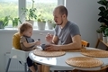 A dad teaching his child to self feeding and helping to eat. A father and baby toddler eating. - PhotoDune Item for Sale