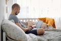 A father working on laptop during child’s daytime sleep. A dad using social media. Working remotely. - PhotoDune Item for Sale