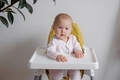 A cute baby sitting in a highchair ready to have dinner.  - PhotoDune Item for Sale