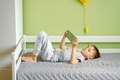 A preschooler lying on bed using mobile. A gen z boy looking intensely playing a game on smartphone. - PhotoDune Item for Sale