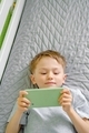 Close up of a cute preschool boy using cellphone for playing, watching video, video chatting.  - PhotoDune Item for Sale