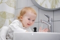 Close up of baby toddler looking at camera and washing hands in the sink. Learning personal hygiene. - PhotoDune Item for Sale