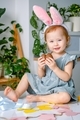 A cute smiling cheerful toddler girl dressed up bunny ears holding easter gift chocolate eggs. - PhotoDune Item for Sale