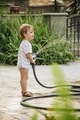 Young boy playing with the hose during a summer heatwave - PhotoDune Item for Sale