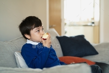 fresh fruit for his snack while watching TV, Portrait  kid face eating food. Healthy food for children concept