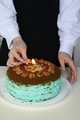 A young Caucasian girl lights a candle on her birthday cake. She's celebrating her birthday. - PhotoDune Item for Sale