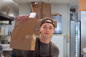 student summer job, part time employment, minimum wage job, preparing customer takeaway food orders, paper bag with lunch, small local business concept