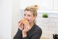 Attractive Young Woman Eating Croissant. Sugar-stained nose. - PhotoDune Item for Sale