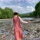 Vintage romantic woman in straw hat, long dress walks on river rocks near forest. Natural scenic - VideoHive Item for Sale