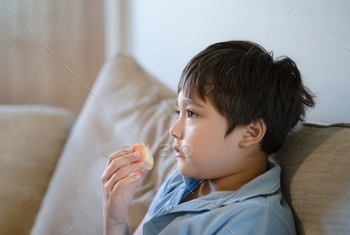 Cute boy eating fresh fruit for his snack, Close up kid face eating food. Healthy food for children concept