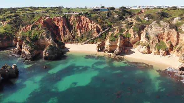 Pristine Camilo Beach in Lagos Idyllic coastline in Algarve, Portugal - Aerial establishing shot