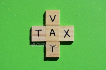 cronym for Value Added Tax, in wooden alphabet letters on a green background