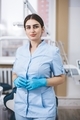 Dark haired woman in medical robe and gloves, doctor in blue clothes looking at camera. - PhotoDune Item for Sale