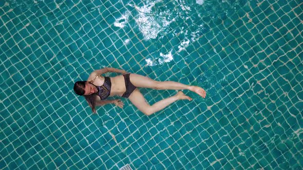 Young Woman Swimming in Open Green Swimming Pool. Outdoor Activities. Healthy Lifestyle. Top View