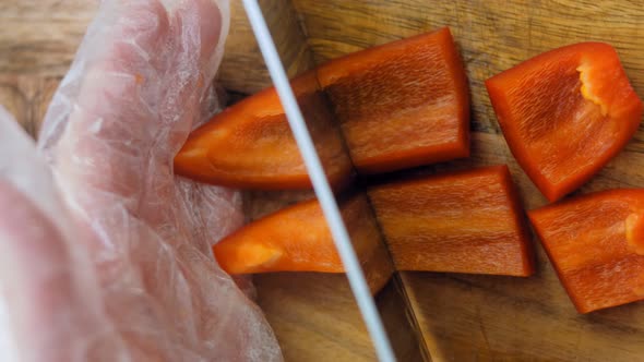 The Chef Cuts Into Squares a Sweet Red Pepper with a Professional Knife