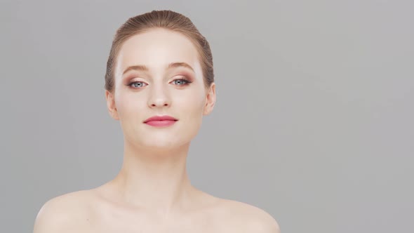 Studio portrait of young, beautiful and natural woman over grey background.