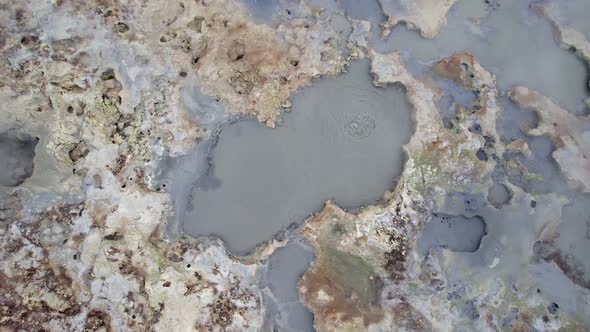 Aerial view tilt up over Hverir geothermal area with boiling water in Iceland