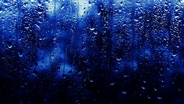 Rainy Background Neon Blue Color, Drops Flow Down The Glass, Copy Space Background.