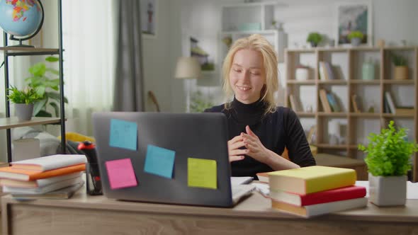 Young Woman Communicating By Video Call at Home in the Living Room at the Desk